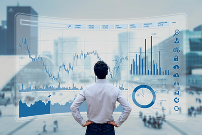 Uomo che guarda grafici economici su uno schermo